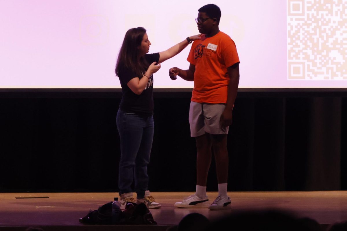 Guest speaker Kate Garnes speaks to a Shawnee Mission Northwest student about his name and its importance.