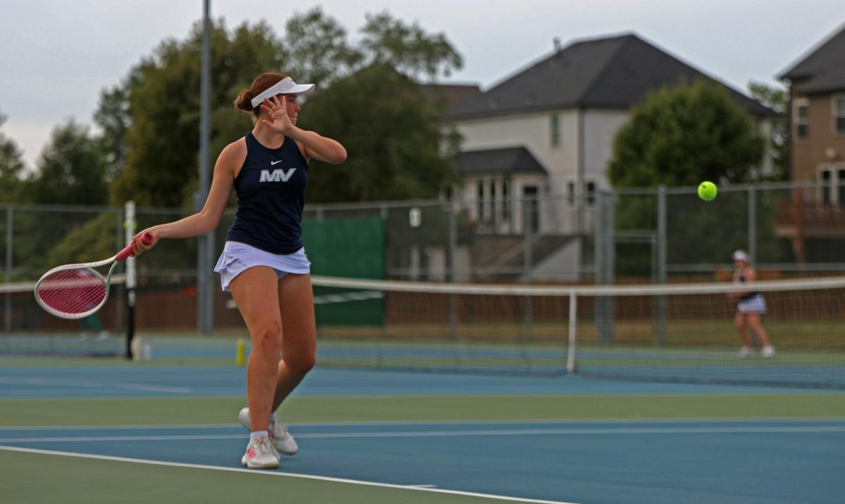 Bringing her racket back, sophomore Zoe Wendel prepares to hit the ball.
