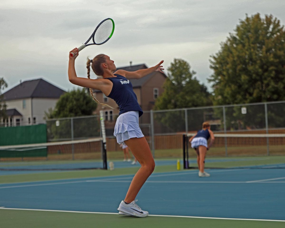 Receiving the serve, senior Bryn Foltz smacks the ball with her racket.
