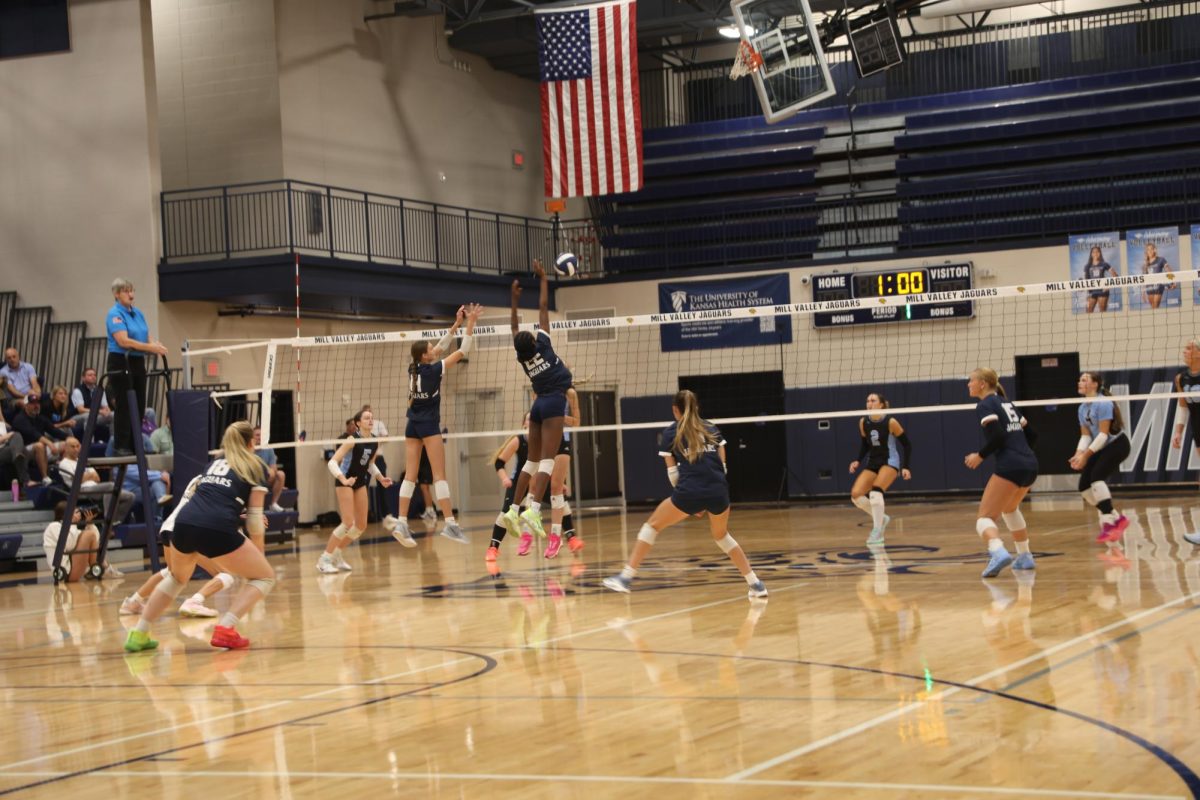 Jumping high, sophomore Alden Laughman and Olivia Nzioki attempt a huge block
