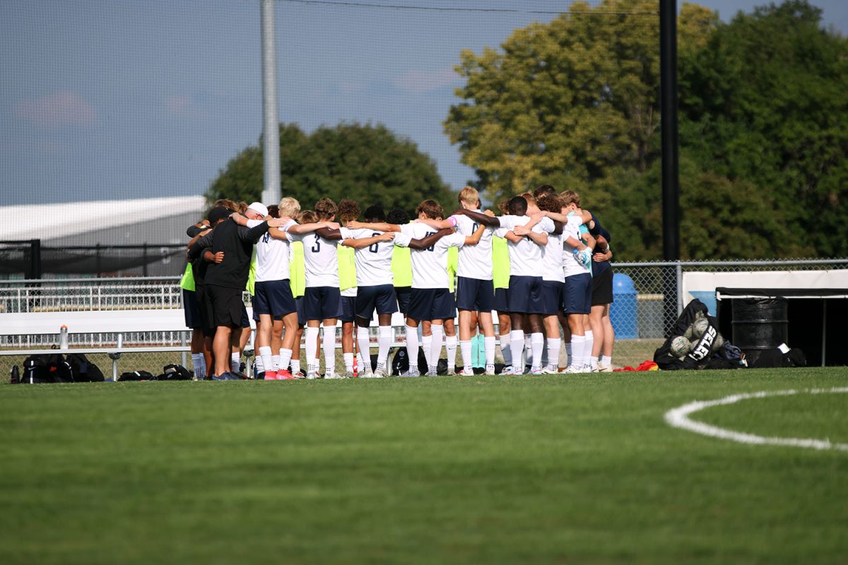 Arms around each other, the boys varsity soccer team huddles before the game. Tuesday Sept. 2.