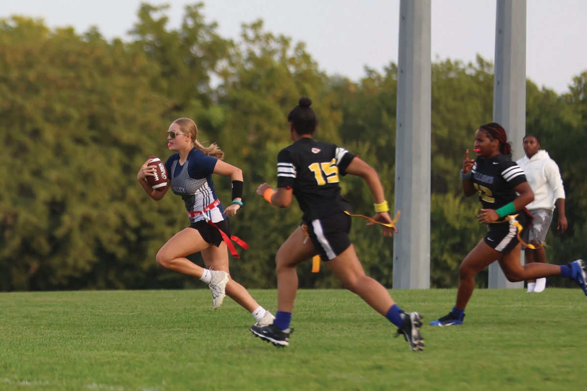 With the ball tucked so it doesn’t drop, junior Kate Mikuls carries the ball right past her defenders for a touchdown during the game on Wednesday, Sept. 3.