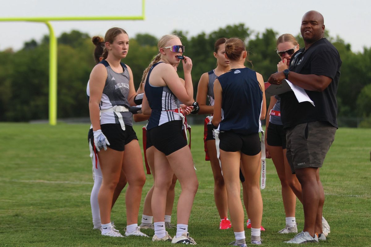 Discussing with his offense team, officer Hillman creates a plan on his clipboard for them to score a touchdown during the game against Wellsville on Wednesday, Sept. 3. 
