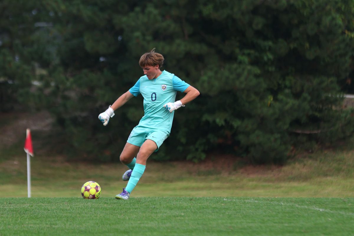 Focusing on his kick, junior Zane Hodson uses all of his leg strength to kick the ball to his teammate at the end of the field. 