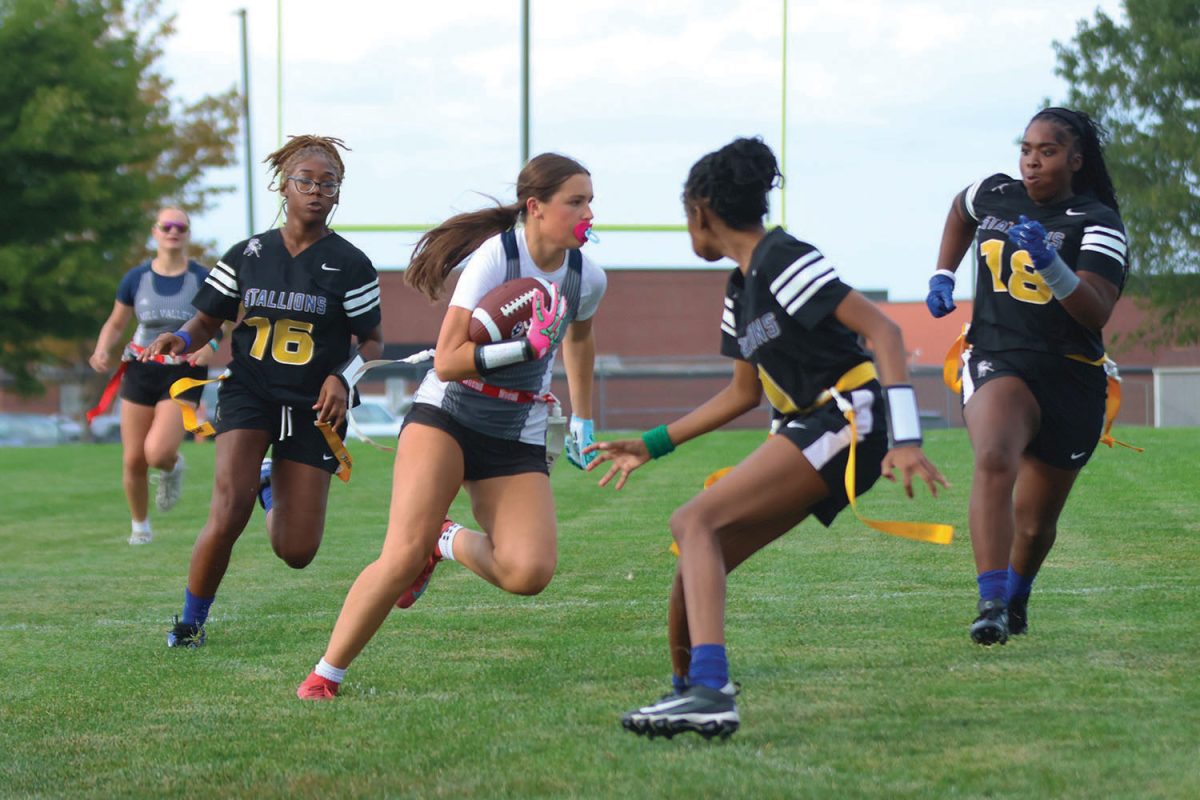 Passing by with ease, sophomore Lauren Woods runs by the defenders trying to grab on to her flag during the game on Wednesday, Sept. 3. 

