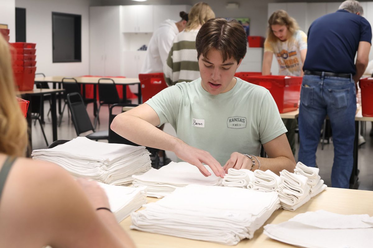 Volunteering at Heart to Heart, senior Barron Fox folds towels for part of the hygiene kit, Thursday, Sept. 18.
