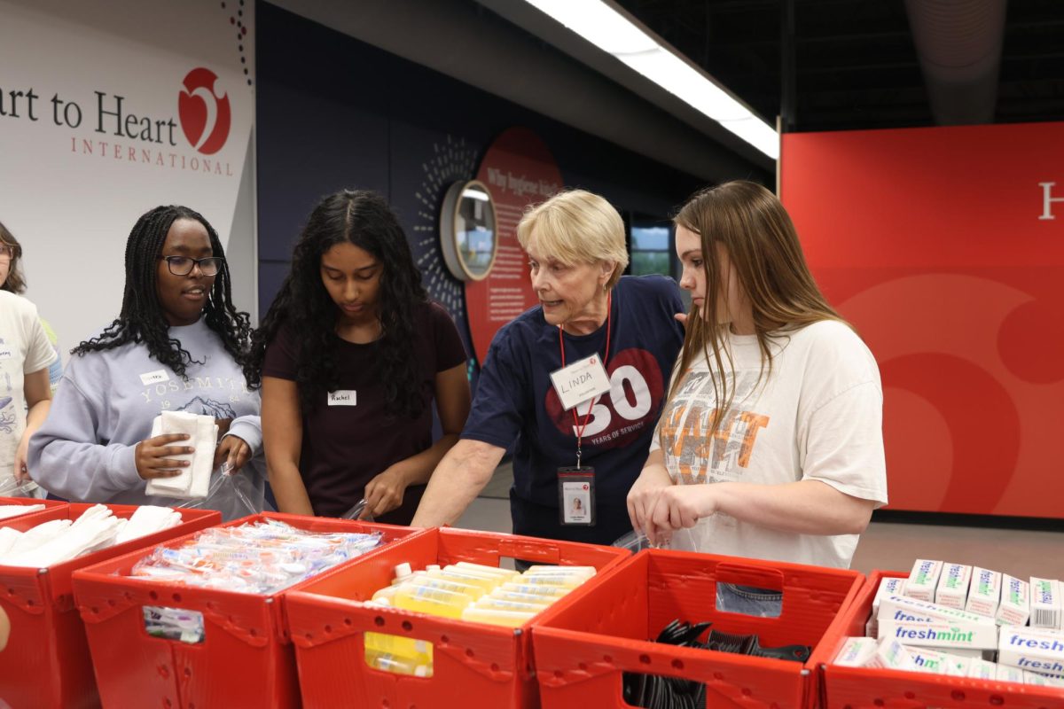 Preparing hygiene kits, seniors Rachel Joseph, Doreen Mahugu and junior Kennedy Botkin listen to the volunteer thats been there for 30 years, Thursday, Sept. 18.