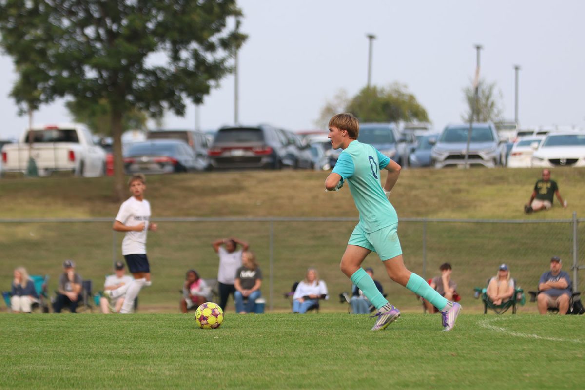 Looking for a teammate to receive the ball, junior Zane Hodson goes to kick the ball to a teammate on the far end of the field. 