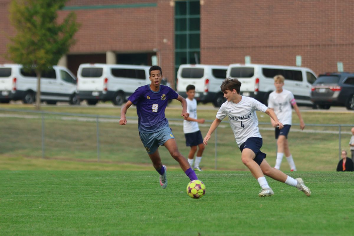 Trying to get around his opponent, junior Brice Zenger sprints to the ball.