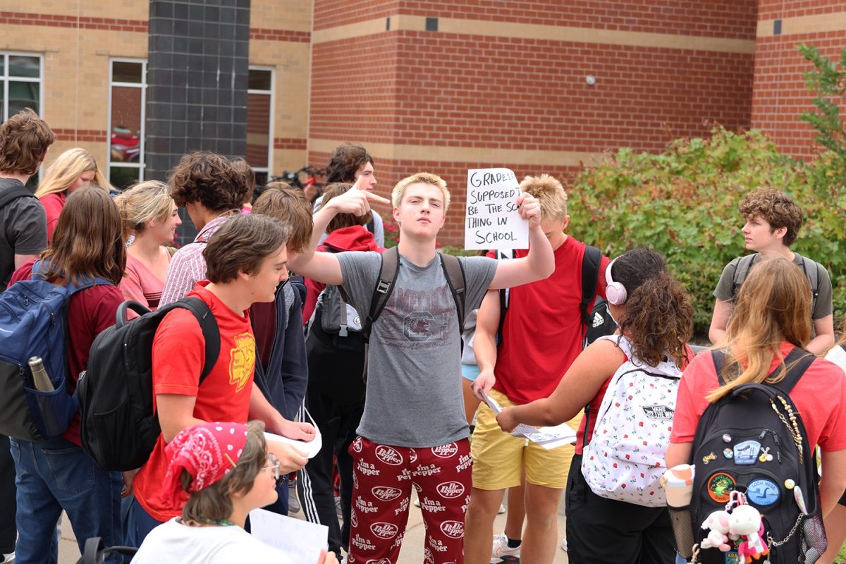 Participating in the protest, sophomore Jack Musil holds a sign "Grades are supposed to be the scary thing in school" to protest against the schools nationwide not protecting their students from gun violence, Friday. Sep. 5.