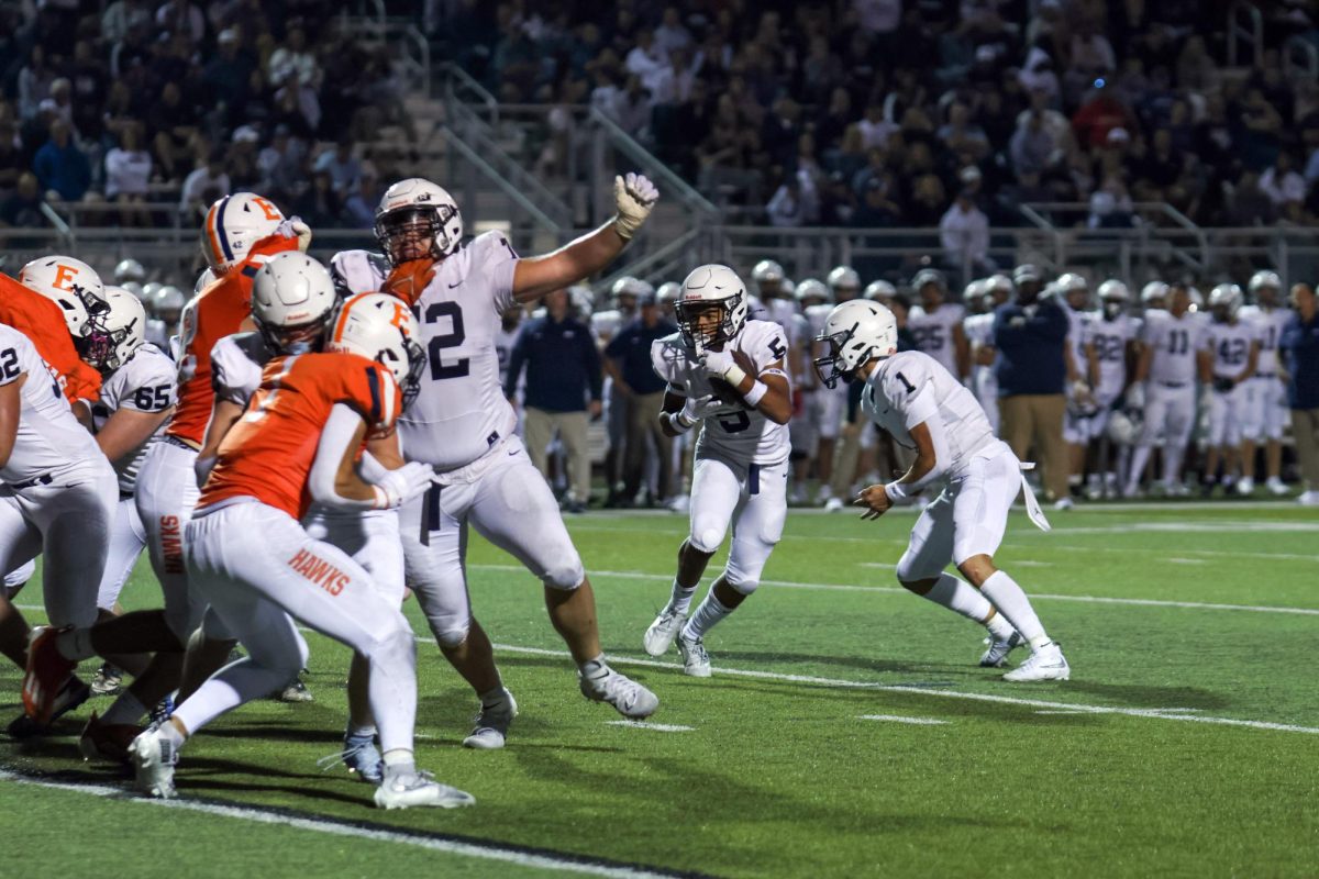 Freshman Nyeem Coleman grabs the ball from senior Blake Jay to make a running play.
