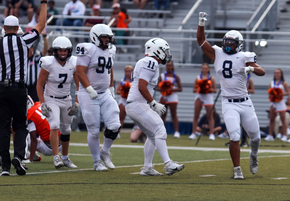 Seniors Hayden Heller, Jaxon Garcia and juniors Larry Jones and Kendyn Charbonneau celebrate stopping the Olathe Easy offense