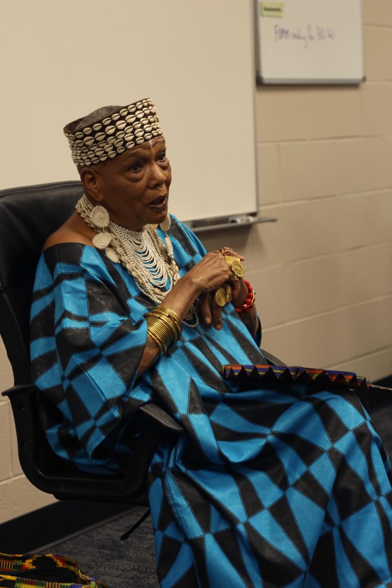 Hands together, speaker Charlotte Hill O'Neal tells the class about her experience as a Black Panther.