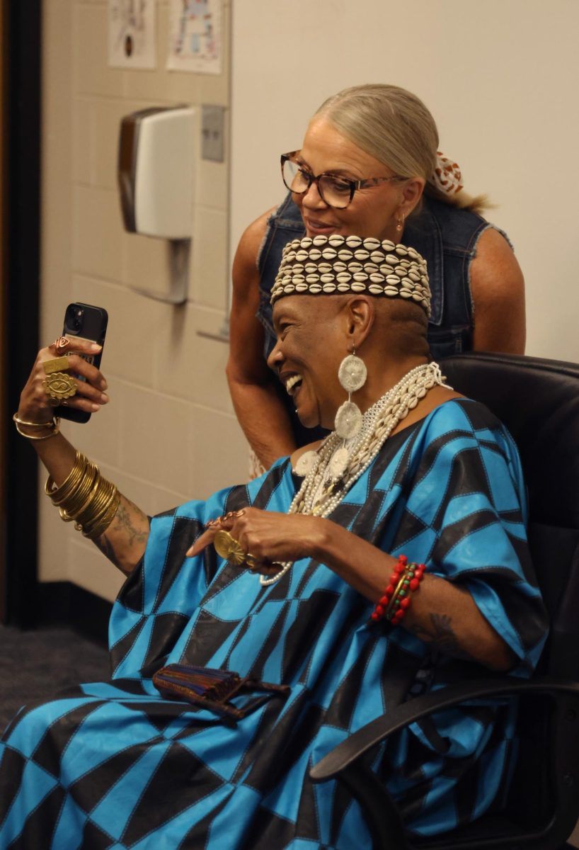 Looking at her phone, principal Dr. Holder says hello to Charlotte Hill O'Neal's husband, Pete O'Neal.