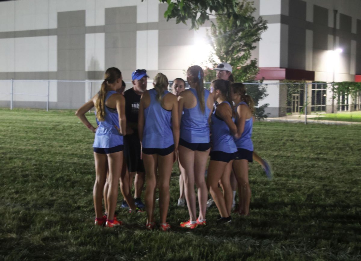 Coach Chris McAfee gives the varsity girls a pep talk before their race.