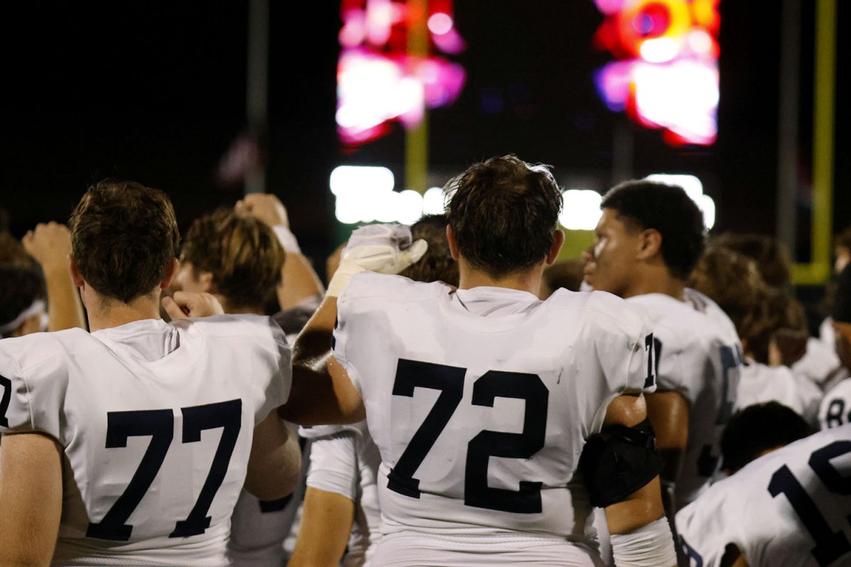 The football team finishes their huddle after the game.
