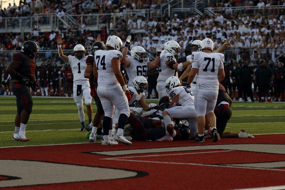The football team runs the ball, scoring a touchdown.
