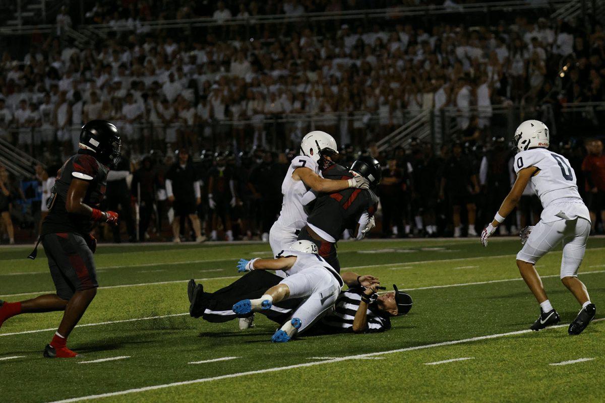 Senior Jaxon Garcia tackles over a referee to stop a run. 