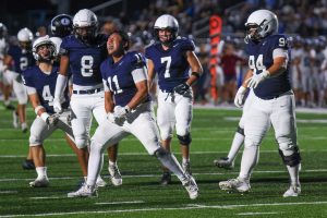 Junior Josh Garcia celebrates with his teammates after sacking Shawnee Mission East’s quarterback.