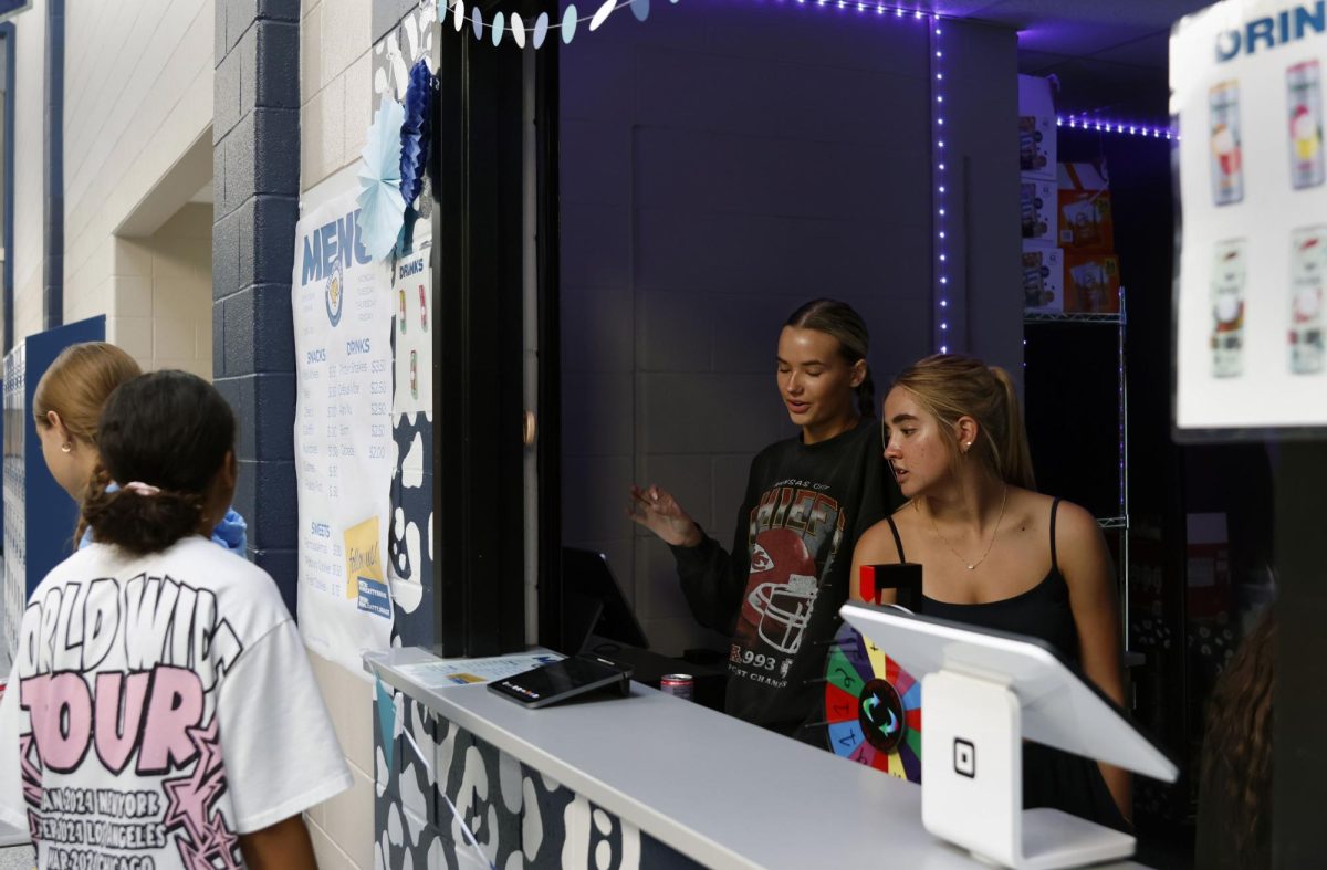 Talking to a customer, senior Clair Cooper takes an order. 