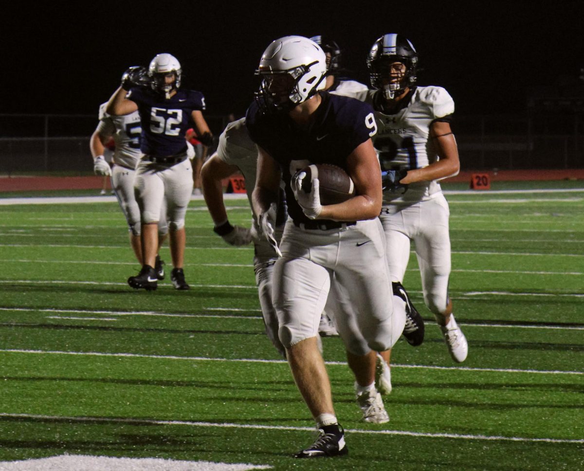 Junior Max Piva runs towards the end zone as he scores a touchdown.