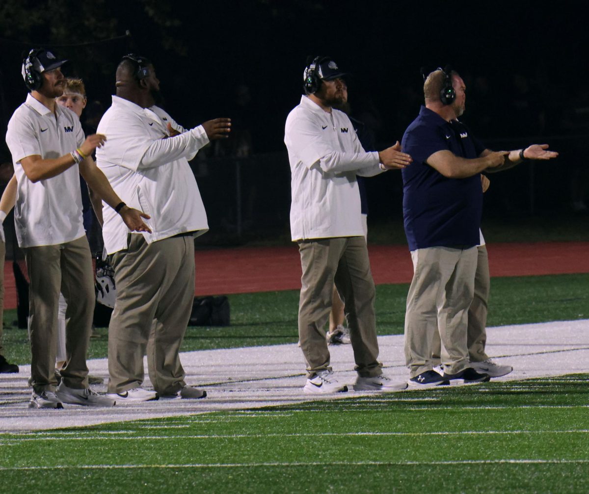 Preparing for the next play, the coaches give the players their signs.