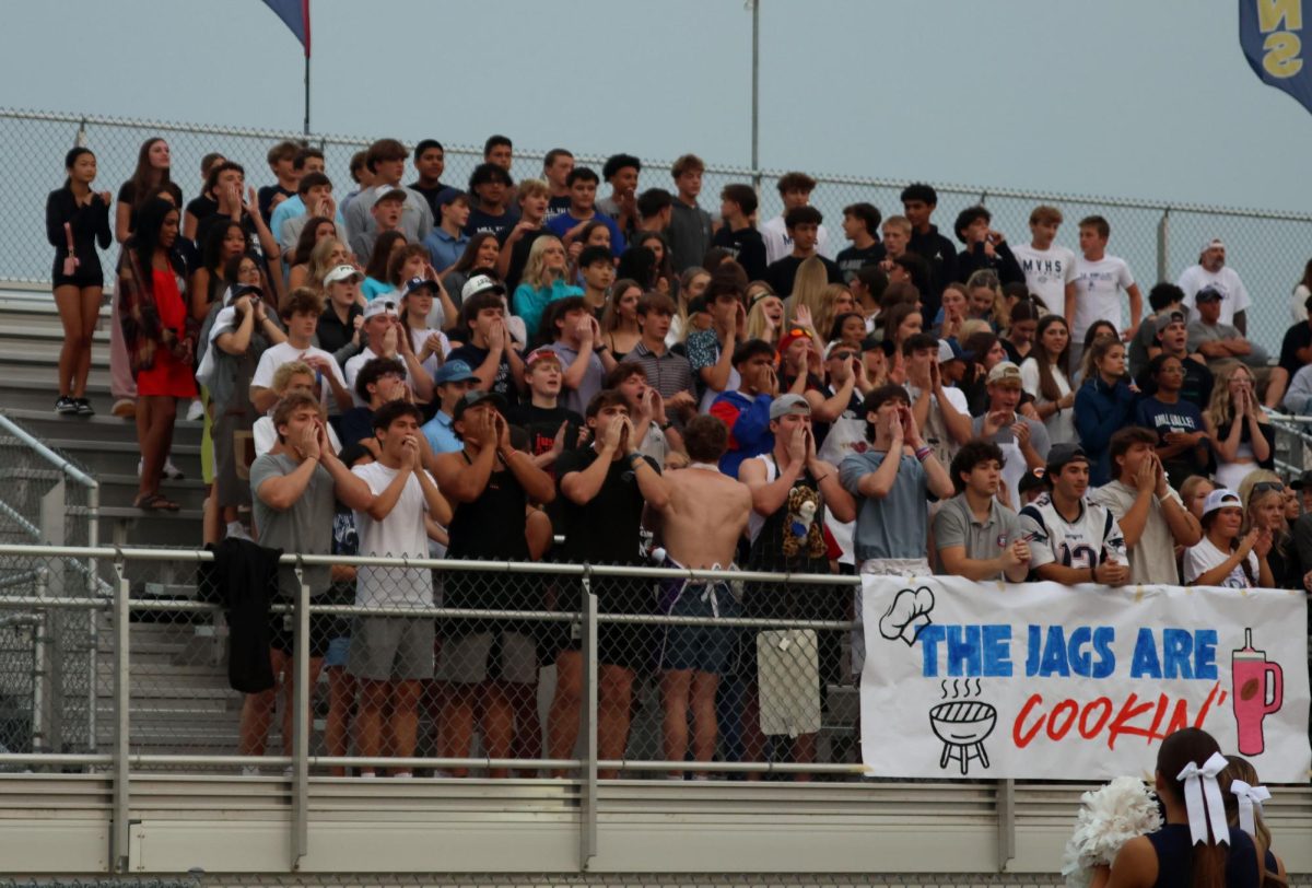The student section cheers loudly while the opposing team punts the ball back to the Jags.