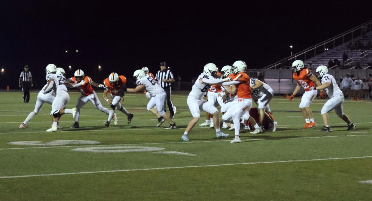The Jaguars fight to keep Olathe East defense off of senior Reggie Reece as he runs with the ball.