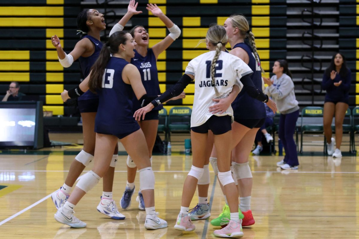 The volleyball team celebrates after winning a point. 