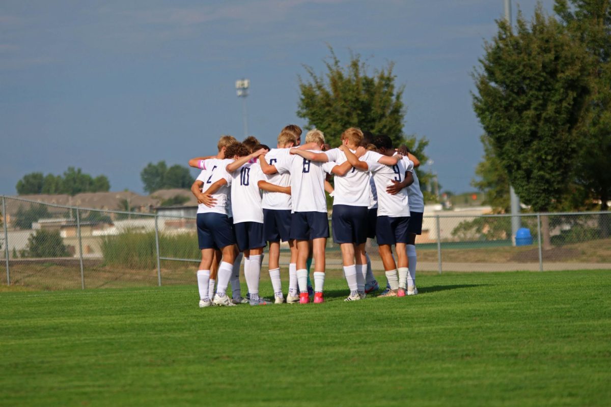 The Varsity boys soccer team huddles together before their game against St. James. 