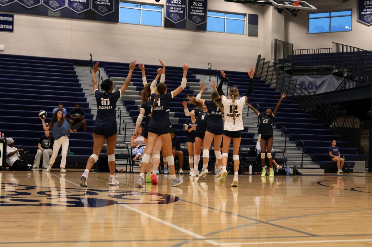 After winning the first set, the Jags cheer with the bench.