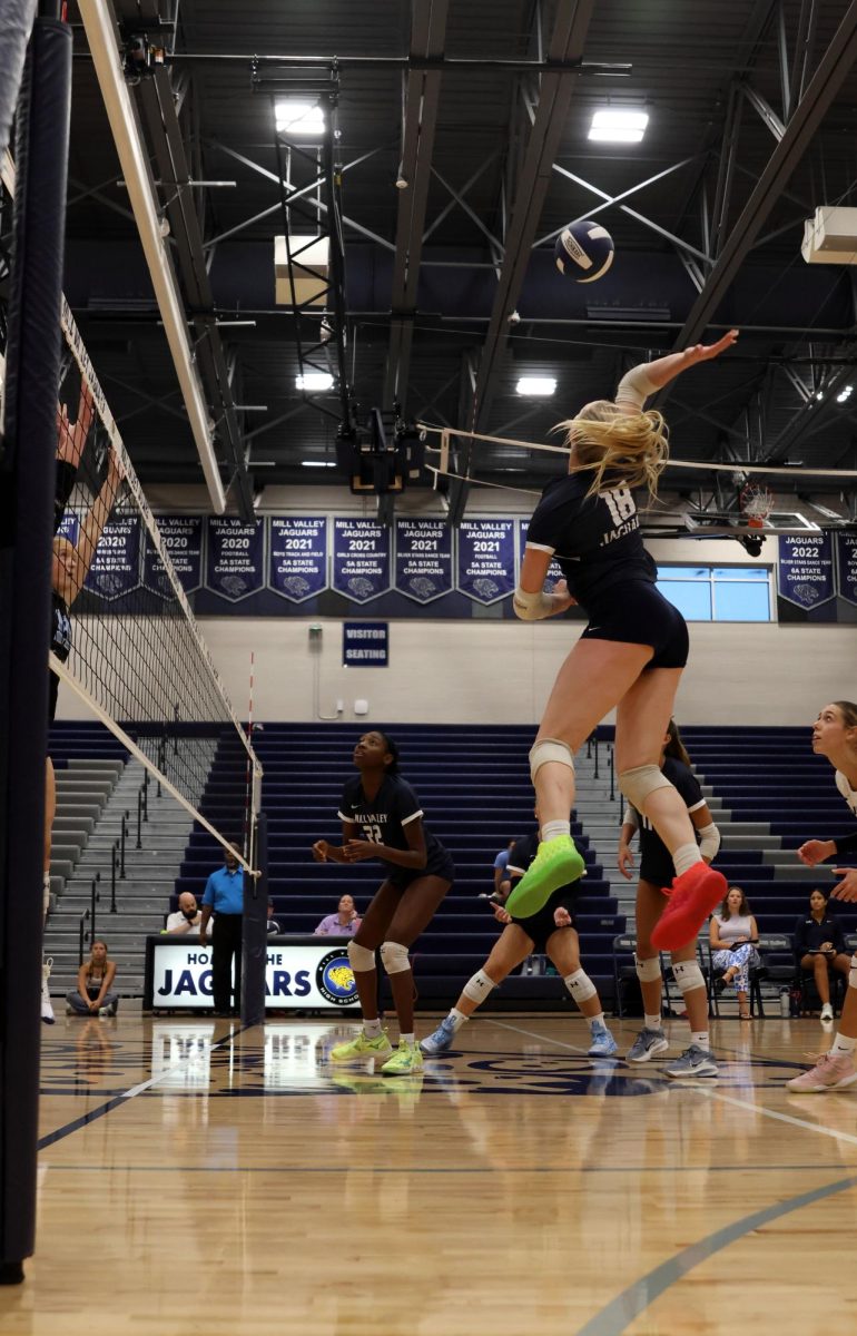 Junior Riley Riggs hits the ball, attempting to get a kill.