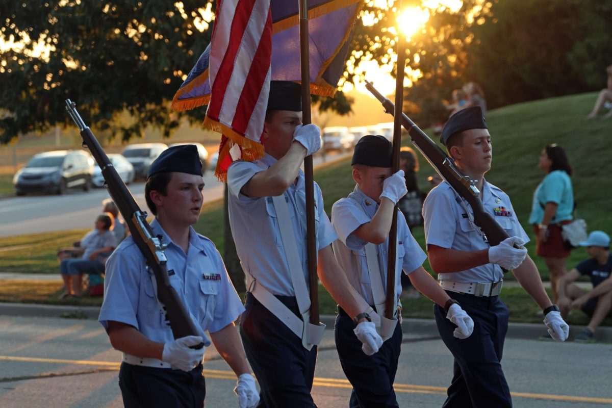 Members of junior ROTC kick off the parade holding both the Kansas state flag and United States flag.