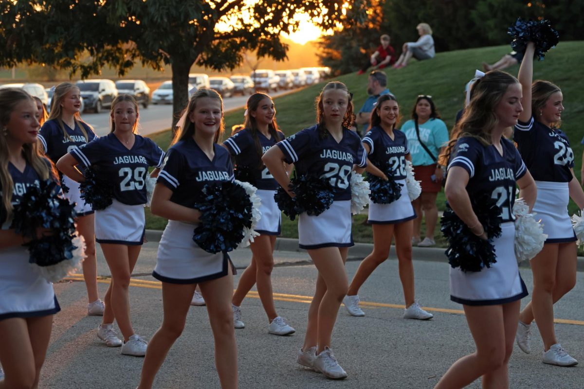 Sophomore Aubrey Birdsong marches alongside her teammates behind the cheer float.