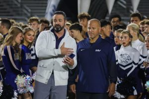 Sanding together, KSHB 41 reporter Taylor Hemness interviews head football coach Joe Applebee. 
