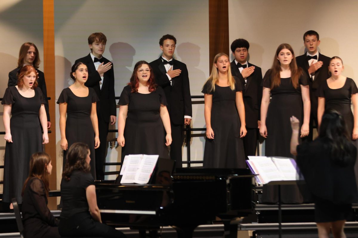 While lower voices create a beat using their hands the Jag Chorale sings and look at choir teacher Laura VanLeeuwen to keep together during the concert on Tuesday, Oct.14. 