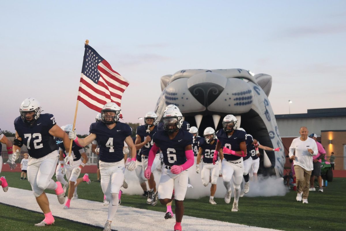 Mill Valley's football team runs out of the tunnel, being led by senior Garrett Cox, against Olathe West. 
