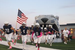 Mill Valley's football team runs out of the tunnel, being led by senior Garrett Cox, against Olathe West. 
