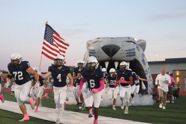 Mill Valley's football team runs out of the tunnel, being led by senior Garrett Cox, against Olathe West. 

