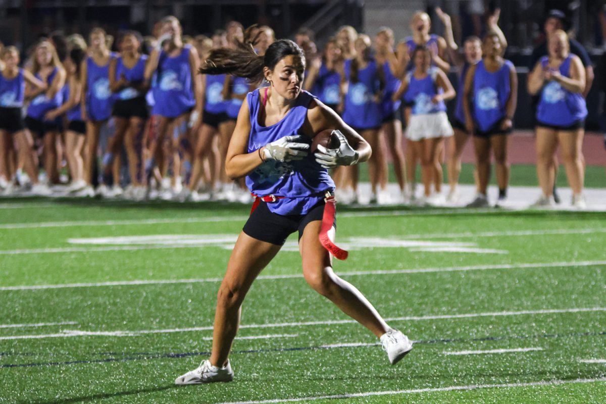 Looking downfield, senior Paige Roth searches for an open pocket to gain a first down.