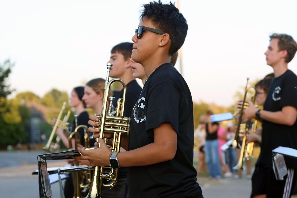 Walking in line, sophomore Sage Olivas performs with the band as they open the parade.