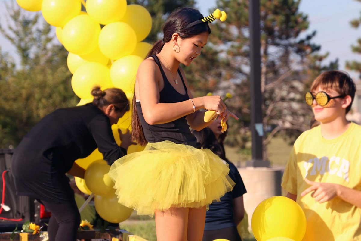 Focused, freshman Kate Nguyen blows up balloons for the freshman float. 
