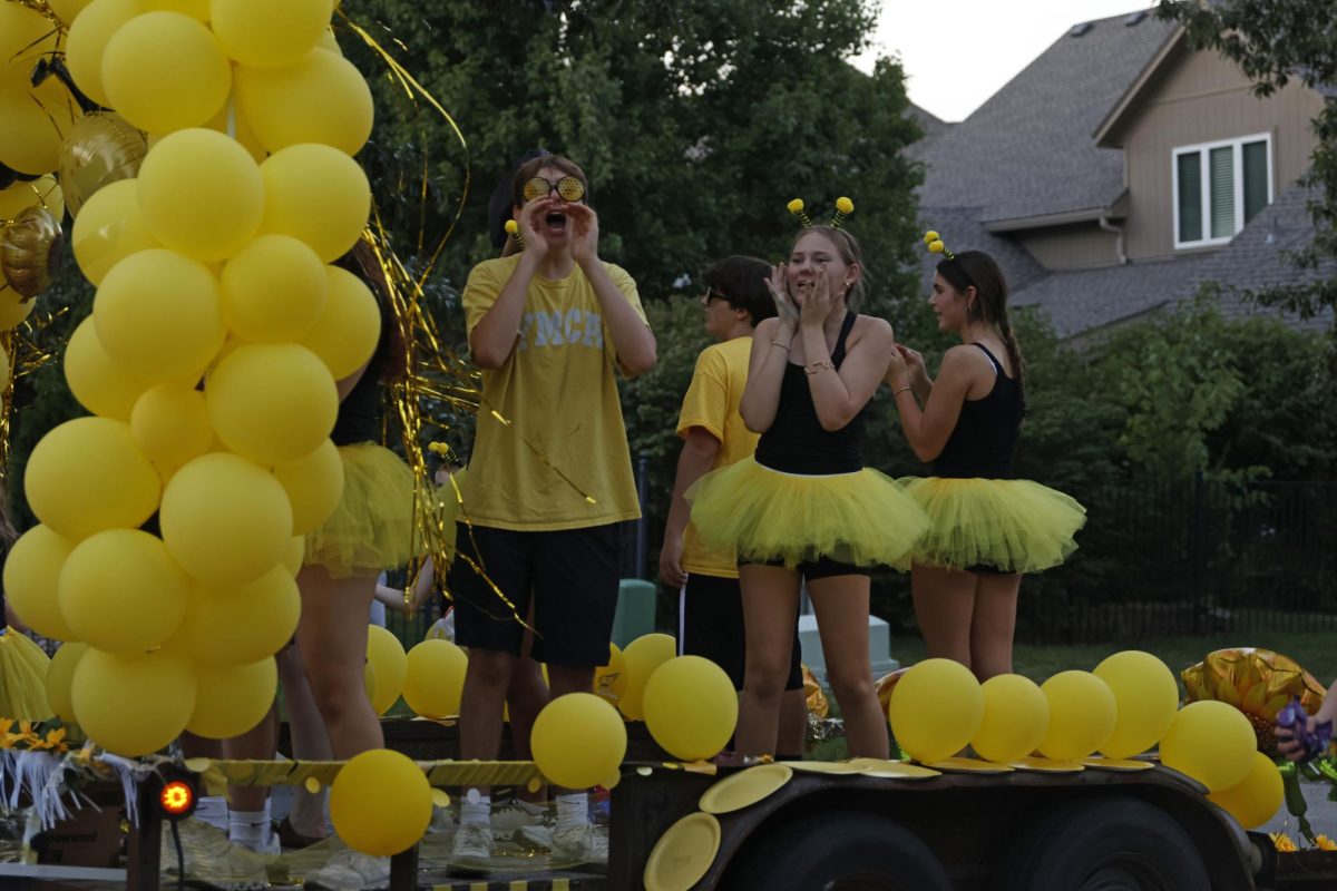 Freshmans Colby Holick and Audrey Huber cheer for from their class float during the homecoming parade. 