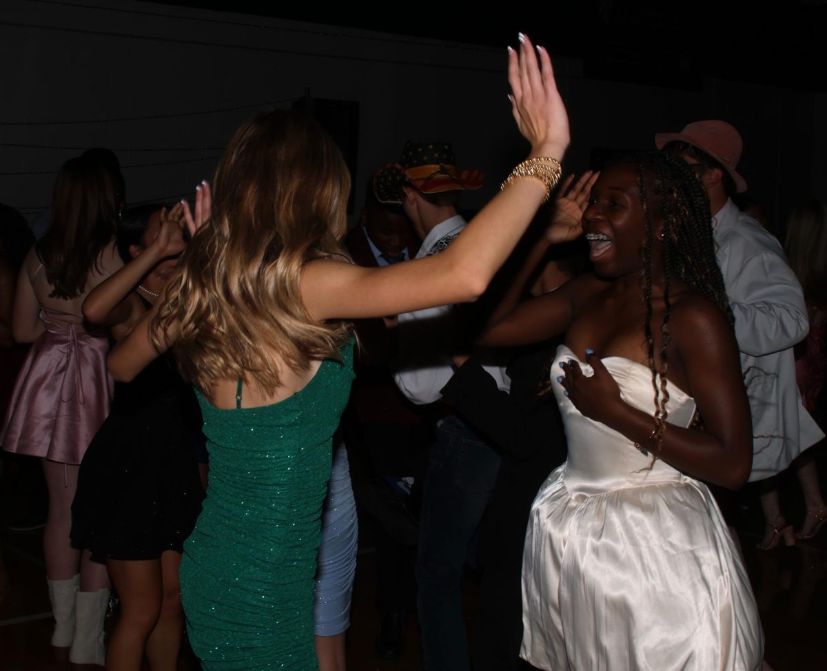 Hands up, sophomore Brynnan King and freshman Loryl Chiles sing along together.