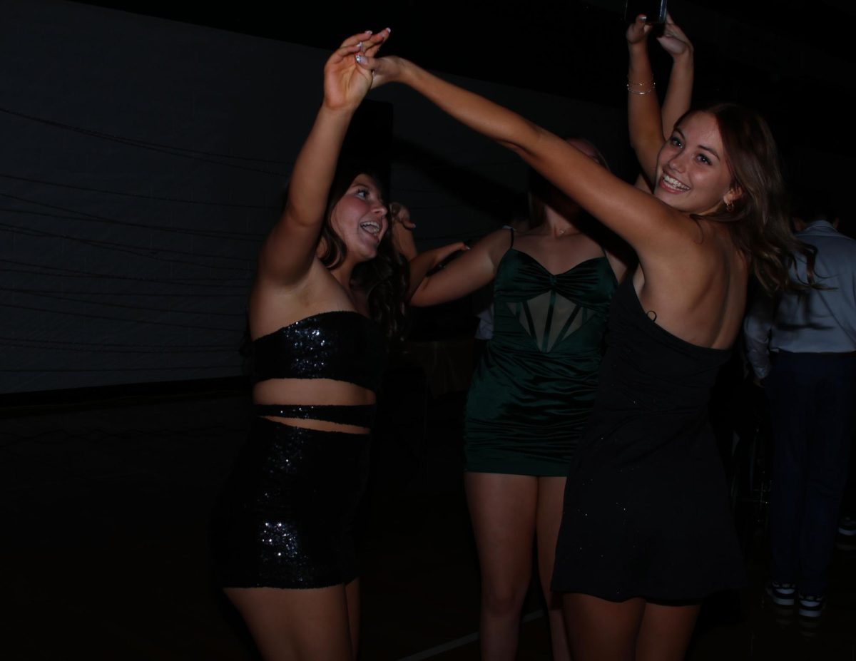 Hands in the air, sophomores Campbell Welton and Danika Middleton dance together.