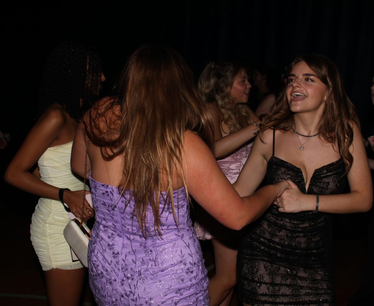 Hands together, sophomores Braedyn Dumlao-Flack and Tessa Legleiter twist to the beat.