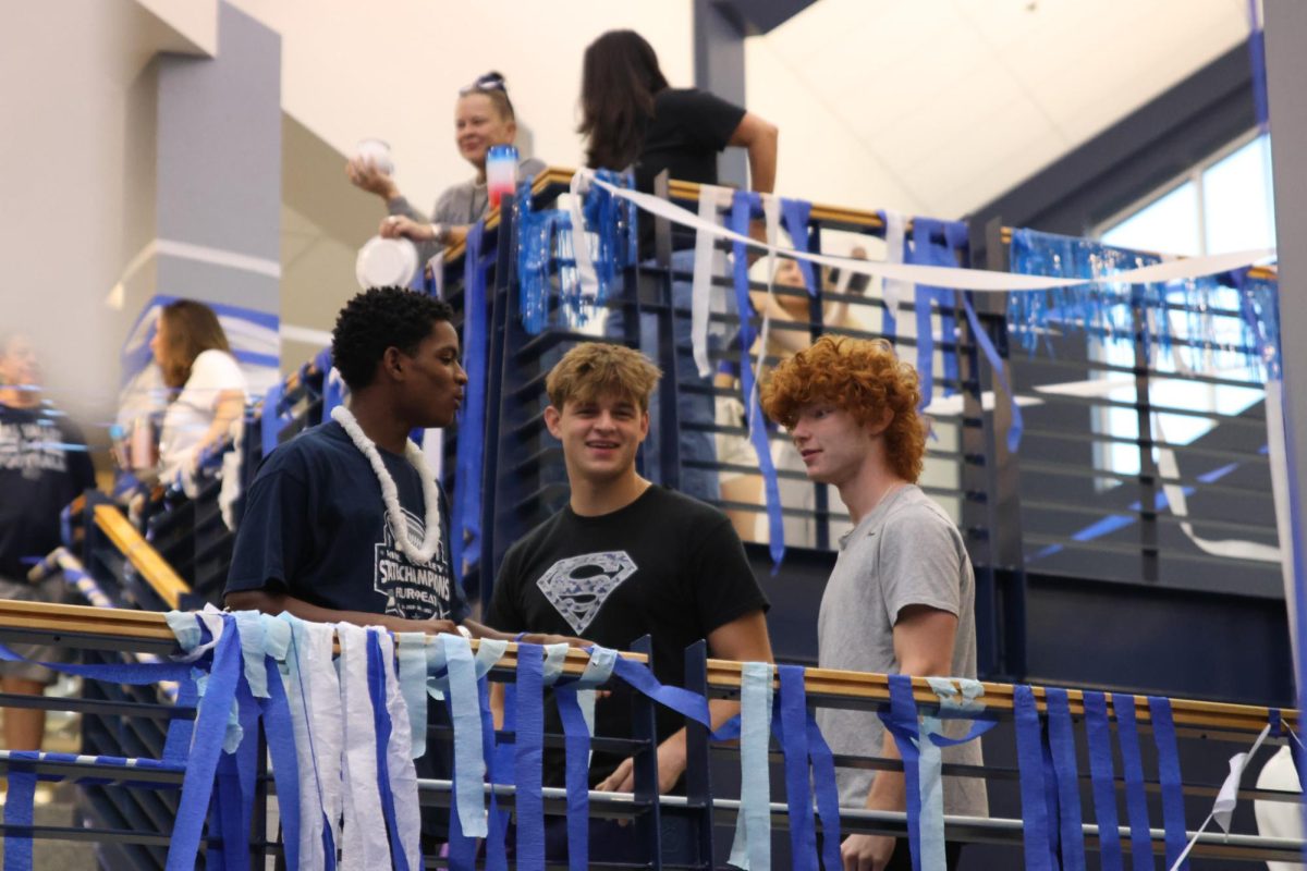 Seniors Alex McReynolds, Devin Edwards and Tyreek Reed converse on the stair landing.