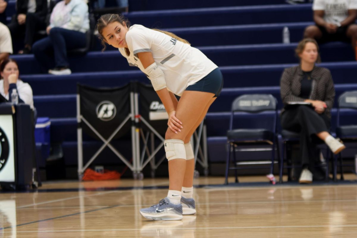 Senior Ella Flores Looking back at her teammates to discuss strategy Senior Ella Flores prepares to serve the ball on Thursday Oct 2.