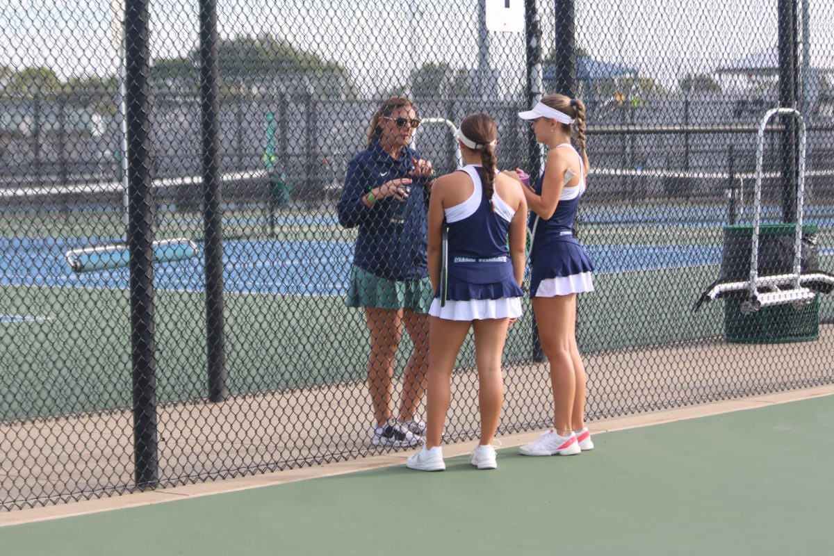 Pointing out her players' mistakes, tennis coach Denise Smith tells them what to improve on during the tennis tournament Saturday, Oct, 11.