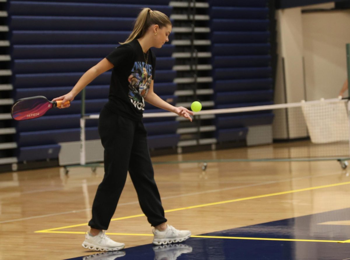 Stepping up to the court, senior Sarah Allerheiligen starts the match with a powerful serve.
